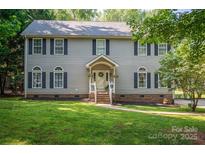 Charming two-story home with gray siding, black shutters, and a welcoming front porch at 1575 Lewis Farm Rd, Kings Mountain, NC 28086