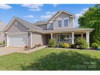 Charming two-story home featuring a covered front porch, well-manicured lawn, and attached two-car garage at 176 Pleasant Grove Ln, Mooresville, NC 28115