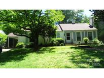 Charming single-story home with a well-manicured lawn and mature trees providing ample shade at 229 W Park Ave, Mooresville, NC 28115