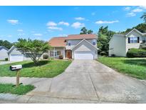 Charming two-story home features a well-manicured lawn, a long driveway, and a front-facing two-car garage at 2706 Stagbuck Dr, Gastonia, NC 28052