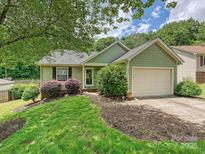 Charming one-story home with green siding, manicured lawn, and an attached one-car garage at 2927 Dubberly Ct, Matthews, NC 28105