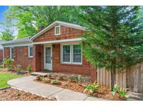 Charming brick home with meticulously landscaped flower beds, offering beautiful curb appeal at 2953 Enfield Rd, Charlotte, NC 28205