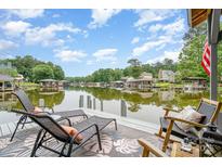 A waterfront view from a private dock, featuring comfortable lounge chairs and scenic lake views under a partly cloudy blue sky at 307 Lake Head Rd, Norwood, NC 28128