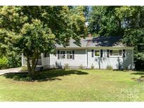 Charming single-story home featuring a well-maintained lawn, light gray siding, and a tree providing shade at 3331 Eastwood Dr, Charlotte, NC 28205
