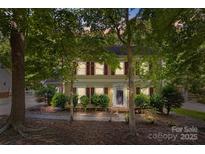 Charming two-story home with red shutters and mature trees in a serene, wooded setting at 4232 Saint Audrey Pl, Charlotte, NC 28269