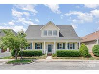 Charming two-story home featuring a covered porch, green shutters and manicured landscaping at 4504 Sages Ave, Indian Trail, NC 28079