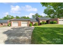 Charming single-story brick home with well-maintained landscaping, driveway, and attached two-car garage at 608 Camrose Ne Cir, Concord, NC 28025