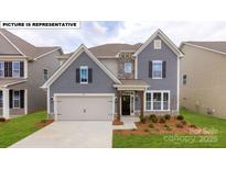 Charming two-story home features a two-car garage, manicured lawn, and inviting entrance at 109 Asmodean Ln, Troutman, NC 28166