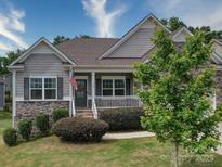 Charming single-Gathering home with stone accents, landscaped yard, and inviting front porch with American flag at 120 Autumn Mist Rd, Statesville, NC 28677