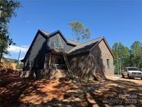 Two-story home under construction featuring a brick and gray corrugated metal exterior and ladder at 124 Third Se St, Hildebran, NC 28602
