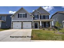 Charming two-story home with a well-manicured lawn, a two car garage and stone and gray toned siding at 127 Asmodean Ln, Troutman, NC 28166