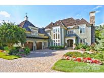 Stately home featuring a brick driveway, manicured landscaping, and a charming exterior with multiple windows at 13837 Grand Palisades Pkwy, Charlotte, NC 28278