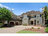 Elegant home with stone accents, multi-car garage and manicured landscaping at 13837 Grand Palisades Pkwy, Charlotte, NC 28278