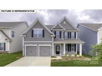 Charming two-story home featuring a symmetrical facade, a two-car garage, and manicured landscaping at 146 Asmodean Ln, Troutman, NC 28166