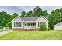Charming single-story home with a well-maintained front yard and a cozy front porch at 2023 E Park Dr, Lancaster, SC 29720