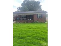 Charming brick home featuring a covered front porch, complemented by a lush green lawn at 202 Kenwood Ave, Cherryville, NC 28021
