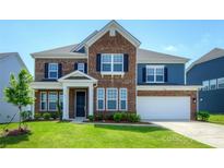 Beautiful two-story brick home featuring classic architecture, a manicured lawn, and attached garage at 256 W Waterlynn Rd, Mooresville, NC 28117