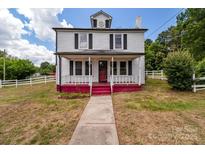 Charming two-story home featuring a covered front porch and white picket fence at 2809 N Main St, Kannapolis, NC 28081