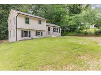 Charming two-story home with black shutters and ample front yard space nestled among mature trees at 3121 Revolution Park Dr, Charlotte, NC 28217