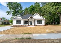 Charming new construction features a modern farmhouse exterior with manicured lawn at 315 W Hoke W St, Landis, NC 28088