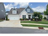 Charming home featuring a manicured lawn, lush landscaping, and a welcoming front entrance at 4527 Waylon Ave, Fort Mill, SC 29715