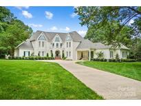 Stunning white brick home with well-manicured lawn, a circular driveway, and inviting curb appeal at 469 Valley Run Dr, Waxhaw, NC 28173