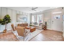 Bright living room featuring stylish decor, a modern ceiling fan, and abundant natural light at 5666 Stafford Rd # 9, Charlotte, NC 28054