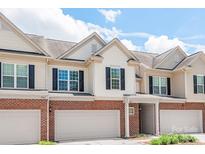 Inviting townhome featuring brick accents, an attached garage, and a covered front entry at 5951 Carrollton Ln, Charlotte, NC 28210