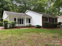 Charming home featuring a well-maintained lawn, a partial brick facade, and eye-catching blue shutters at 7212 Bradley Ct, Charlotte, NC 28227
