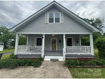 Charming gray home featuring a cozy front porch with white railings and a well-manicured lawn at 103 Duke St, Great Falls, SC 29055