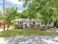 Charming single-story home featuring a cozy front porch and mature trees on a green lawn at 106 Deaver St, Chester, SC 29706