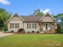Charming single-story home features wood accents, shutters, and a well-manicured front yard at 107 Pressley St, Clover, SC 29710