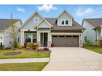 Charming home with a two car garage, beautiful landscaping, and a welcoming front porch at 1318 Encore Ln, Waxhaw, NC 28173