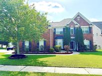 Charming two-story brick home with a beautifully landscaped front yard and mature tree at 16012 Caranna Ct, Charlotte, NC 28277
