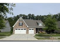 Charming, two-story home featuring a stone facade, manicured lawn, and a two-car garage at 1905 Tranquility Blvd, Lancaster, SC 29720