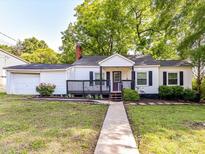 Charming home featuring a covered front porch, a well-maintained lawn, and mature trees at 22 Walnut Nw Ave # 1, Concord, NC 28027