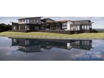 Stunning modern home exterior with sleek lines reflected in tranquil water at 22554 John Gamble Rd, Cornelius, NC 28031