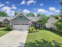 Charming single-story home featuring a two-car garage, manicured lawn, and an inviting covered entryway at 2364 Delaney Dr, Fort Mill, SC 29715
