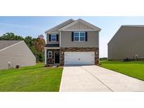 Charming two-story home with a well-manicured lawn, a two-car garage, and a stone and gray siding facade at 2611 Goose Fair Rd, Maiden, NC 28650
