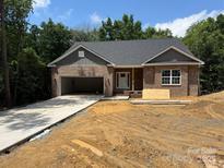 Newly constructed single-story brick home featuring an attached garage and unfinished landscaping at 2924 Noritake Trl # 67, Albemarle, NC 28001