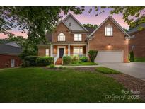 Charming two-story brick home with a manicured lawn and inviting front porch, perfect for relaxing evenings at 310 E Waterlynn Rd, Mooresville, NC 28115