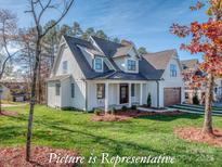 Charming two-story white home with a covered porch, manicured lawn, and beautiful landscaping at 3439 Stags Leap Way, York, SC 29745