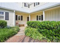 Charming home entrance with lush landscaping and a classic bench, inviting guests at 3810 Selwyn Farms Ln # 3, Charlotte, NC 28209
