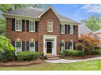 Classic brick home featuring black shutters, a well-manicured lawn, and a welcoming front entrance at 3909 Black Sycamore Dr, Charlotte, NC 28226