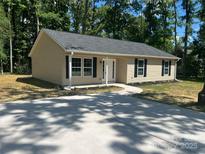 Tan single story home with black shutters, new gray roof, sidewalk and wide driveway at 507 Putter Pl, Chester, SC 29706