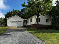 Charming single Gathering home featuring a two-car garage, neutral siding and a well maintained lawn and gravel driveway at 5359 Lake Glenn Dr, Stanfield, NC 28163