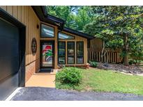 Inviting entrance with large windows, black trim, and colorful welcome decor, showcasing a blend of modern and classic design at 6119 Bittersweet Ln, Charlotte, NC 28270