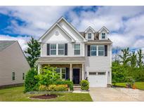 Charming two-story home with white siding, black shutters, covered porch, and a well-manicured lawn at 922 Bunker Trce, Rock Hill, SC 29730