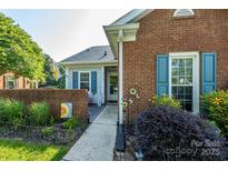 Charming home featuring a brick exterior, inviting walkway, and well-manicured landscaping at 9239 N Vicksburg Park Ct, Charlotte, NC 28210