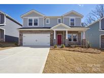 Charming two-story home featuring a stone facade, white garage door, and a vibrant red front door at 116 Obadiah Ct, Mooresville, NC 28115